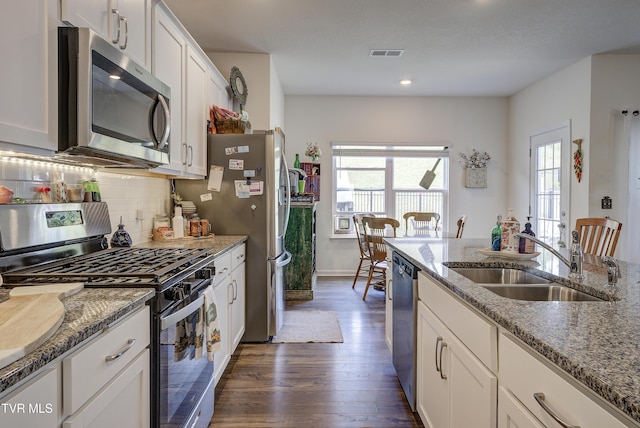 5402 Wildlife Cir, Piney Flats, TN 37686 - kitchen featuring appliances with stainless steel finishes, dark wood-type flooring, white cabinets, decorative backsplash, and light stone countertops