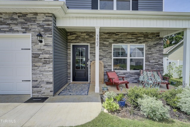 5402 Wildlife Cir, Piney Flats, TN 37686 - property entrance featuring covered porch, stone siding, and a garage
