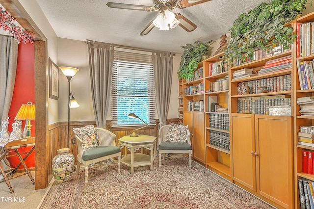 4700 Weaver Pike, Bluff City, TN 37618 - sitting room featuring a textured ceiling, ceiling fan, wainscoting, wooden walls, and carpet