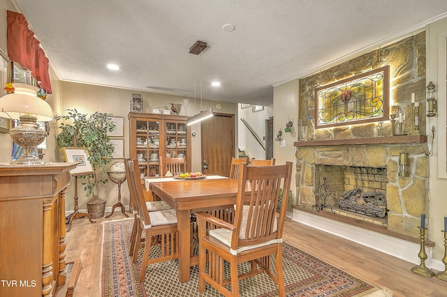 4700 Weaver Pike, Bluff City, TN 37618 - dining area with light wood-style floors, a textured ceiling, a stone fireplace, ornamental molding, and recessed lighting