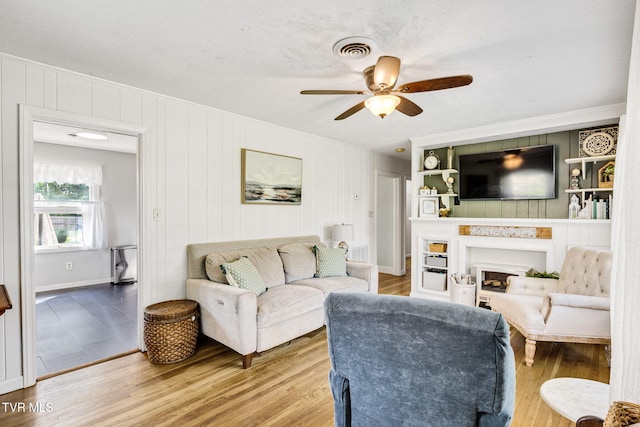 20301 Wood Howell Rd, Bristol, VA 24202 - living room featuring a ceiling fan, wood finished floors, crown molding, and a fireplace