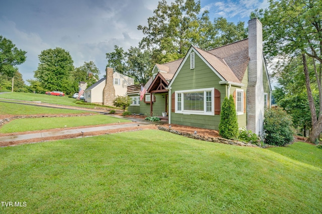 1121 Watauga St, Kingsport, TN 37660 - view of front of house featuring a front yard, a chimney, and a shingled roof