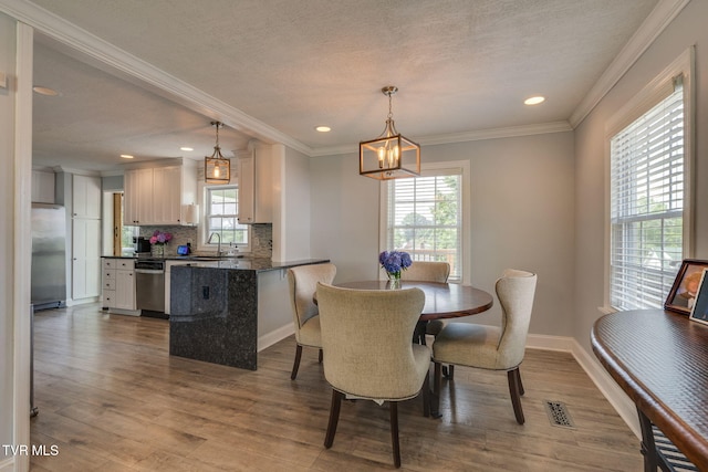 1121 Watauga St, Kingsport, TN 37660 - dining area with a chandelier, wood finished floors, ornamental molding, recessed lighting, and a textured ceiling
