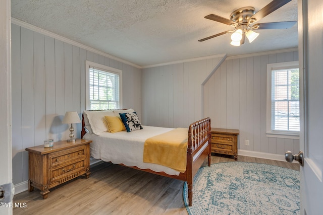 1121 Watauga St, Kingsport, TN 37660 - bedroom featuring ornamental molding, multiple windows, wood finished floors, a textured ceiling, and ceiling fan