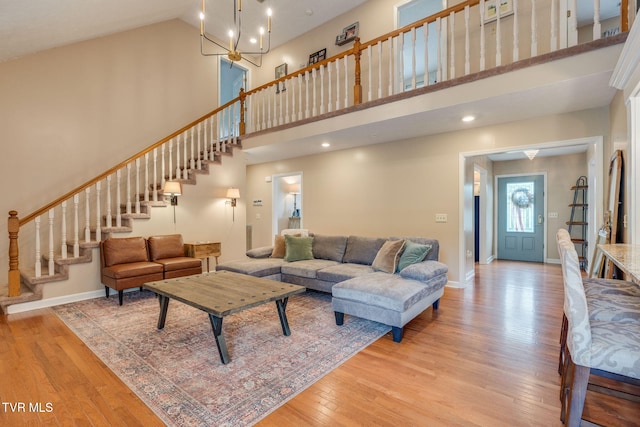 2424 Rivermont Dr, Kingsport, TN 37660 - living room with light wood-style flooring, a towering ceiling, stairs, and a chandelier