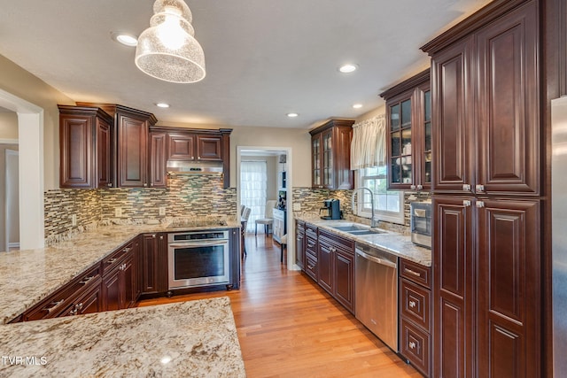 2424 Rivermont Dr, Kingsport, TN 37660 - kitchen featuring appliances with stainless steel finishes, light wood-style flooring, light stone counters, glass insert cabinets, and tasteful backsplash