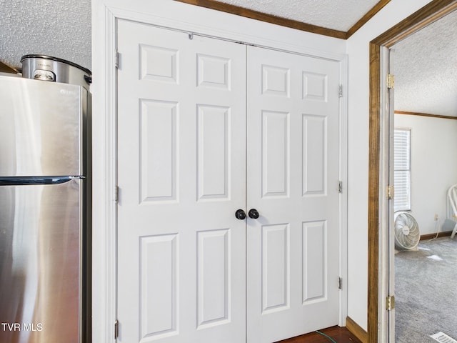 109 Wampler St, Kingsport, TN 37665 - kitchen view of freestanding refrigerator, ornamental molding, a textured ceiling, and dark colored carpet
