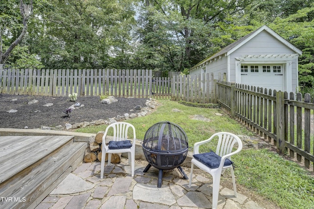 3277 Ashley St, Kingsport, TN 37664 - fenced backyard featuring a fire pit, an outbuilding, a garage, and view of wooded area