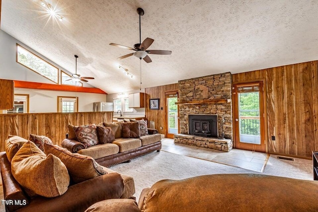 2480-2482 Elk Way, Newport, TN 37821 - living room featuring wood walls, ceiling fan, a textured ceiling, lofted ceiling, and a stone fireplace