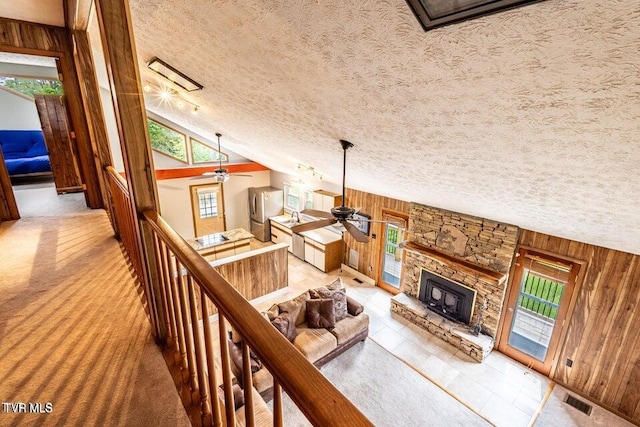 2480-2482 Elk Way, Newport, TN 37821 - living room featuring a ceiling fan, wooden walls, a stone fireplace, plenty of natural light, and a textured ceiling
