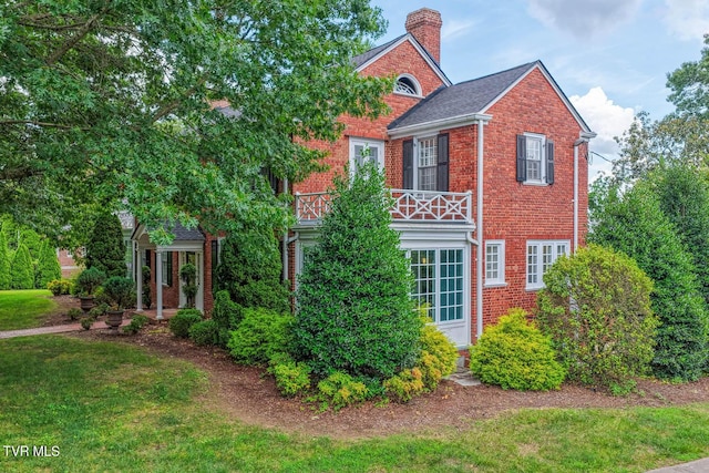 1261 Watauga St, Kingsport, TN 37660 - view of front facade featuring brick siding, a chimney, a front yard, and a balcony