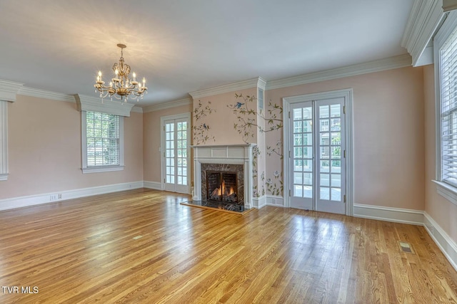 1261 Watauga St, Kingsport, TN 37660 - unfurnished living room featuring light wood-style flooring, a chandelier, a fireplace, and crown molding