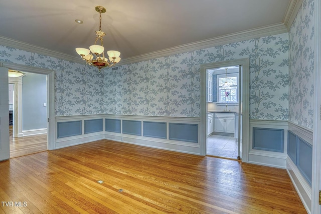 1261 Watauga St, Kingsport, TN 37660 - unfurnished dining area with a chandelier, wood-type flooring, wainscoting, crown molding, and wallpapered walls