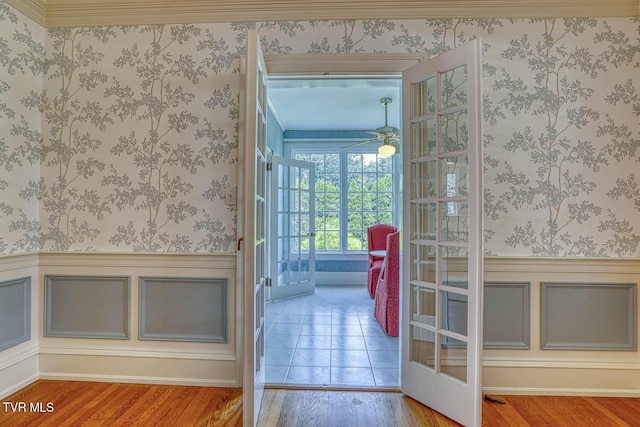 1261 Watauga St, Kingsport, TN 37660 - doorway featuring wood finished floors, wainscoting, ceiling fan, and wallpapered walls