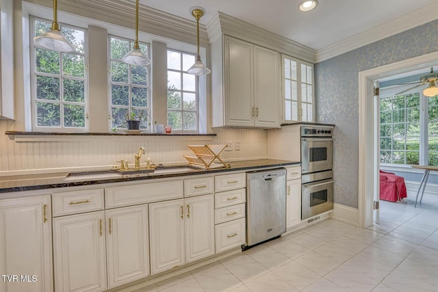 1261 Watauga St, Kingsport, TN 37660 - kitchen with appliances with stainless steel finishes, wallpapered walls, dark stone countertops, pendant lighting, and crown molding