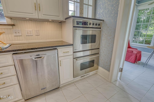 1261 Watauga St, Kingsport, TN 37660 - kitchen with appliances with stainless steel finishes, wallpapered walls, light marble finish floors, white cabinetry, and dark stone countertops