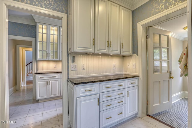 1261 Watauga St, Kingsport, TN 37660 - kitchen featuring wallpapered walls, ornamental molding, dark stone countertops, white cabinetry, and light marble finish floors