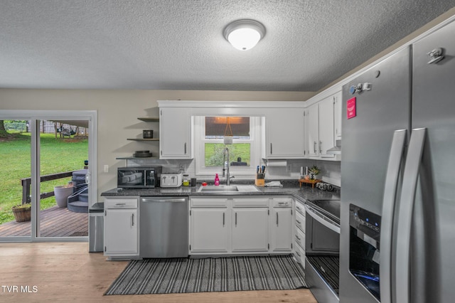 3020 Ridgemont Cir, Kingsport, TN 37663 - kitchen featuring appliances with stainless steel finishes, dark countertops, open shelves, a textured ceiling, and white cabinetry