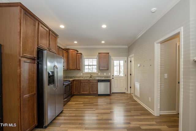 1900 Knob Creek Rd Unit 404, Johnson City, TN 37604 - kitchen featuring appliances with stainless steel finishes, wood finished floors, crown molding, recessed lighting, and brown cabinetry