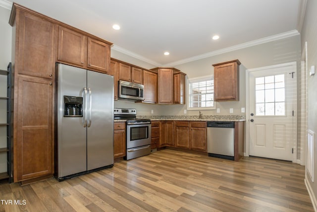 1900 Knob Creek Rd Unit 404, Johnson City, TN 37604 - kitchen with stainless steel appliances, crown molding, brown cabinets, light wood-style floors, and light stone countertops