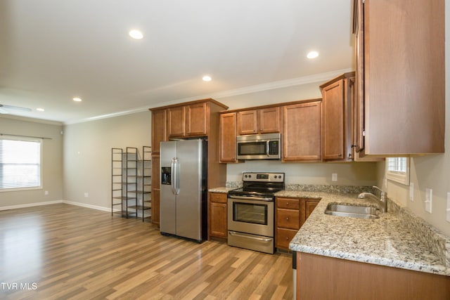 1900 Knob Creek Rd Unit 404, Johnson City, TN 37604 - kitchen featuring stainless steel appliances, brown cabinetry, ornamental molding, light wood-type flooring, and light stone countertops