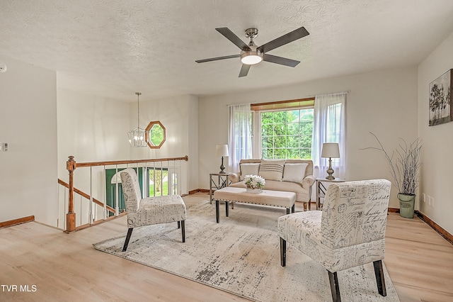 4970 Old Stage Rd, Chuckey, TN 37641 - living area featuring light wood finished floors, a chandelier, a ceiling fan, and a textured ceiling