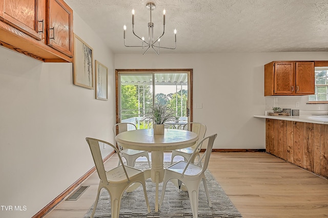 4970 Old Stage Rd, Chuckey, TN 37641 - dining room featuring light wood-style floors, a chandelier, and a textured ceiling