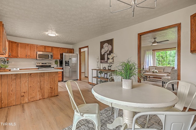4970 Old Stage Rd, Chuckey, TN 37641 - dining space with light wood-style flooring, a textured ceiling, and ceiling fan