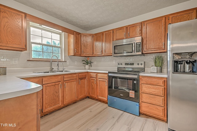 4970 Old Stage Rd, Chuckey, TN 37641 - kitchen with appliances with stainless steel finishes, light wood finished floors, tasteful backsplash, light countertops, and brown cabinetry