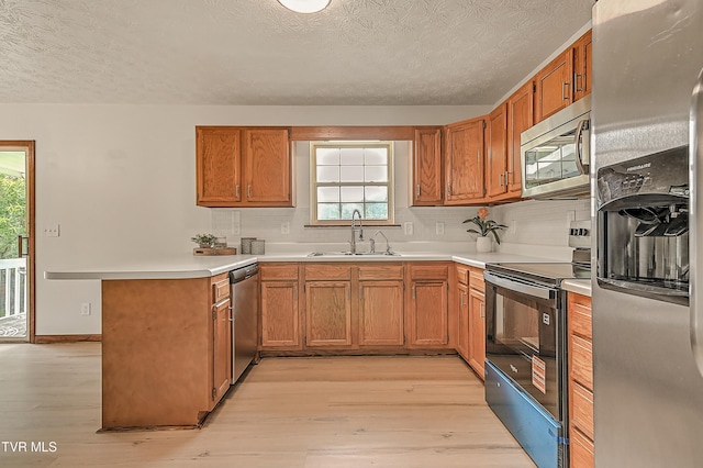 4970 Old Stage Rd, Chuckey, TN 37641 - kitchen with stainless steel appliances, a textured ceiling, light wood-style flooring, a peninsula, and plenty of natural light