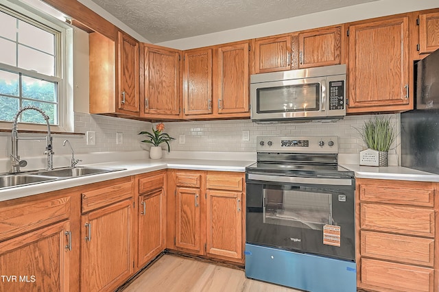 4970 Old Stage Rd, Chuckey, TN 37641 - kitchen featuring stainless steel microwave, electric stove, light countertops, and brown cabinetry