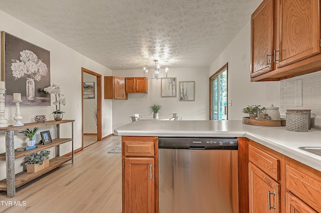 4970 Old Stage Rd, Chuckey, TN 37641 - kitchen with dishwasher, a peninsula, brown cabinets, light wood-type flooring, and light countertops
