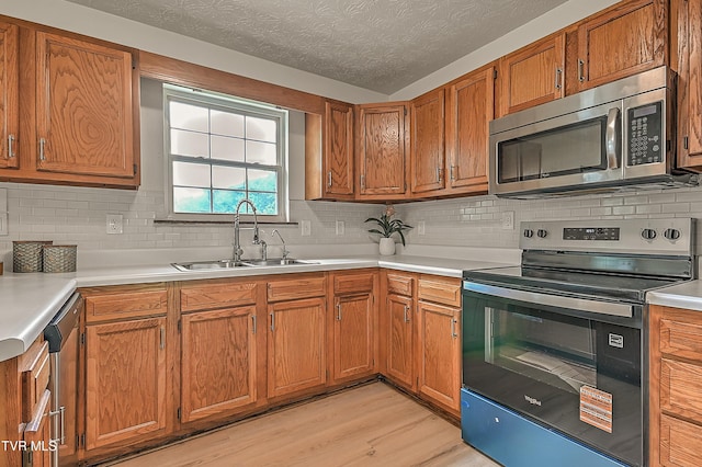 4970 Old Stage Rd, Chuckey, TN 37641 - kitchen with stainless steel appliances, backsplash, light countertops, light wood-type flooring, and brown cabinets