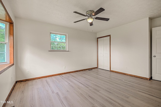4970 Old Stage Rd, Chuckey, TN 37641 - unfurnished bedroom featuring light wood-type flooring, multiple windows, a closet, a textured ceiling, and ceiling fan