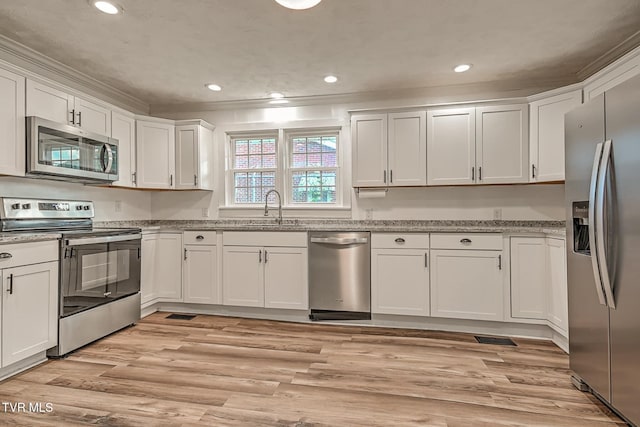 810 N Roan St, Elizabethton, TN 37643 - kitchen featuring appliances with stainless steel finishes, white cabinetry, light stone counters, recessed lighting, and light wood-type flooring