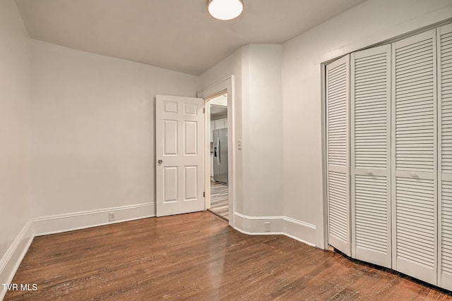 810 N Roan St, Elizabethton, TN 37643 - unfurnished bedroom featuring stainless steel fridge, dark wood-style flooring, and a closet