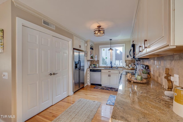 13 Crown Cir, Kingsport, TN 37660 - kitchen with stainless steel appliances, ornamental molding, decorative backsplash, light wood finished floors, and hanging light fixtures