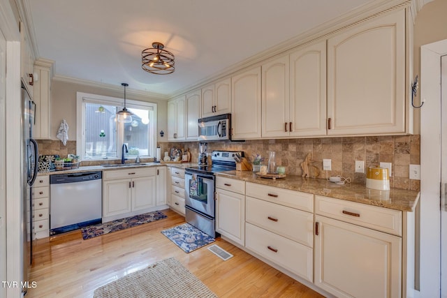 13 Crown Cir, Kingsport, TN 37660 - kitchen with appliances with stainless steel finishes, cream cabinetry, light wood-style floors, tasteful backsplash, and ornamental molding