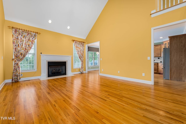 2003 Hackberry Dr, Jonesborough, TN 37659 - unfurnished living room with high vaulted ceiling, light wood-type flooring, a fireplace with flush hearth, and recessed lighting