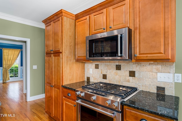2003 Hackberry Dr, Jonesborough, TN 37659 - kitchen with appliances with stainless steel finishes, backsplash, crown molding, light wood-style floors, and dark stone countertops