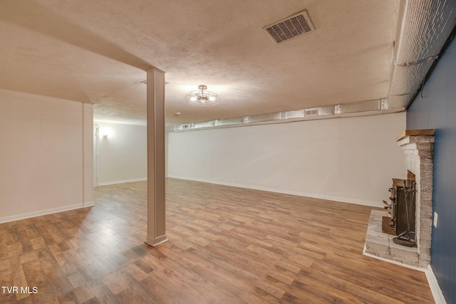 3513 Crest Rd, Kingsport, TN 37664 - finished basement with a textured ceiling, wood finished floors, and a brick fireplace