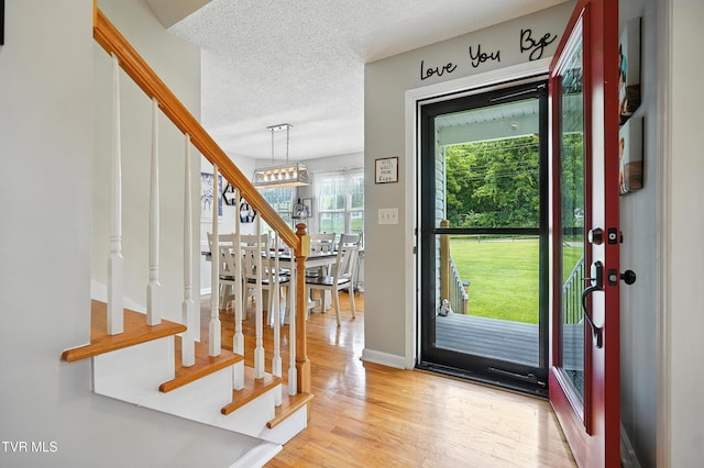 563 Old Jonesboro Rd, Bristol, TN 37620 - entryway featuring stairs, light wood-style flooring, a textured ceiling, and a chandelier