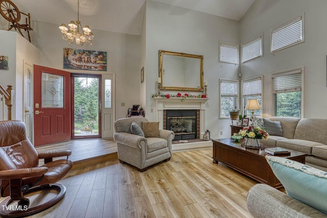 223 Willowbend Ct, Kingsport, TN 37660 - living area featuring high vaulted ceiling, a chandelier, healthy amount of natural light, light wood finished floors, and a tile fireplace