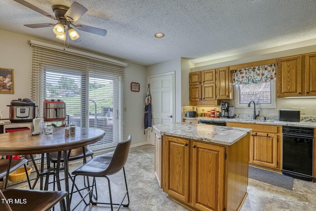 223 Willowbend Ct, Kingsport, TN 37660 - kitchen featuring a kitchen island, a textured ceiling, brown cabinets, ceiling fan, and light stone counters