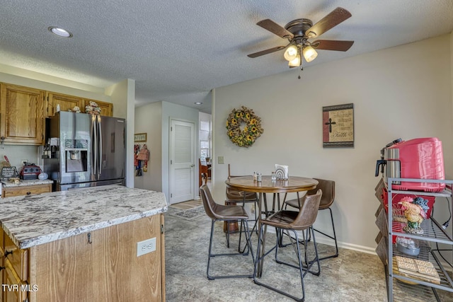 223 Willowbend Ct, Kingsport, TN 37660 - kitchen with stainless steel fridge with ice dispenser, brown cabinetry, light countertops, a ceiling fan, and a textured ceiling