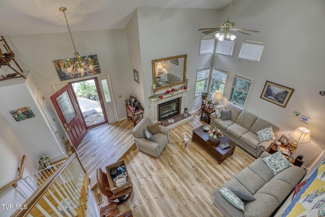 223 Willowbend Ct, Kingsport, TN 37660 - living area featuring high vaulted ceiling, a chandelier, wood finished floors, a glass covered fireplace, and ceiling fan