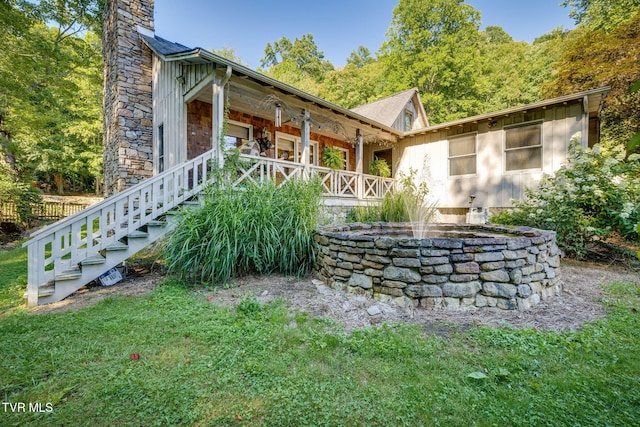 284 Bulldog Holw, Elizabethton, TN 37643 - view of side of home with a porch, a chimney, board and batten siding, and stone siding
