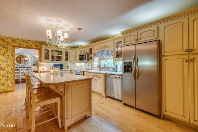 284 Bulldog Holw, Elizabethton, TN 37643 - kitchen featuring appliances with stainless steel finishes, wallpapered walls, light wood-style floors, a chandelier, and a kitchen island