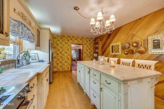 284 Bulldog Holw, Elizabethton, TN 37643 - kitchen featuring range, a center island, wallpapered walls, a chandelier, and light wood-style flooring