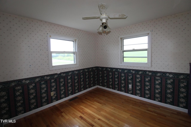 288 Hicks Rd, Piney Flats, TN 37686 - empty room featuring wallpapered walls, plenty of natural light, wood finished floors, and a ceiling fan